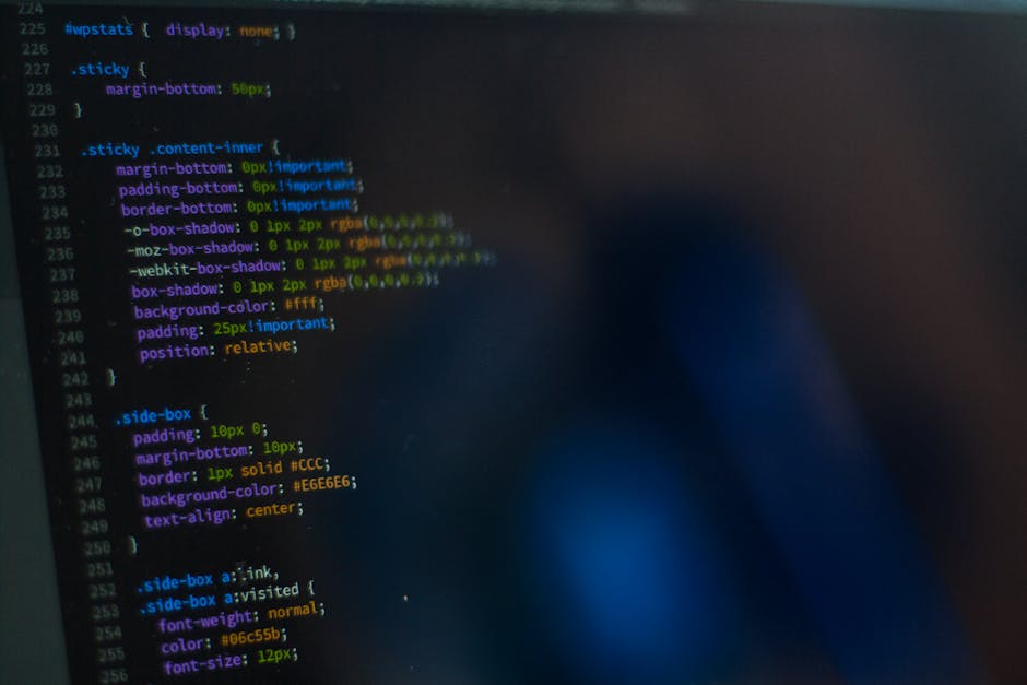 A detailed close-up of a computer screen displaying lines of colourful coding and programming language text, with the text including various CSS styles such as margin, border, background-color, and pa